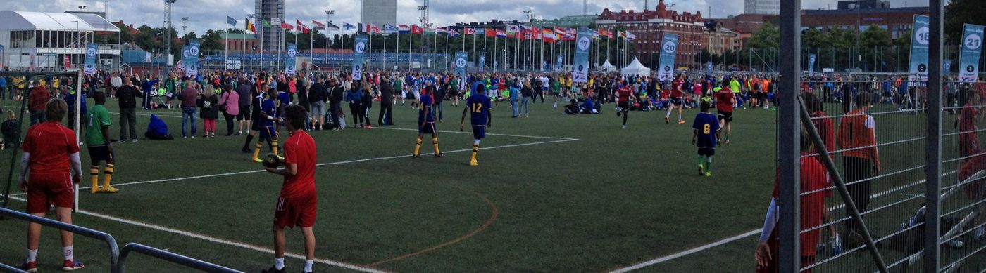 Bild på Hedens fotbollsplan under turnering. På planen syns deltagare med idrottskläder i olika färger.
