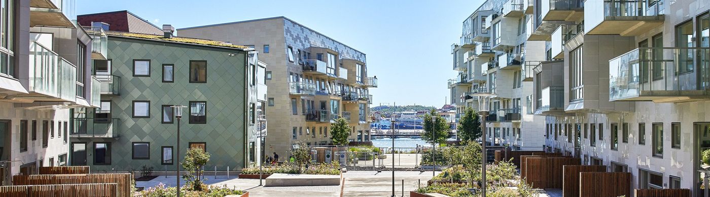 Bild på Lindholmshamnen en solig dag med ljusa byggnader med glasbalkonger.