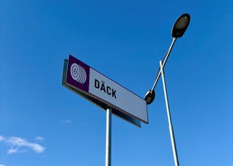 En långsmal skylt med en däcksymbol följt av texten däck. 