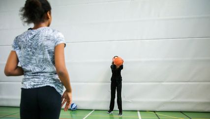 Två personer som kastar boll.