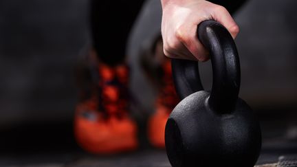 En hand som håller en kettlebell i närbild.