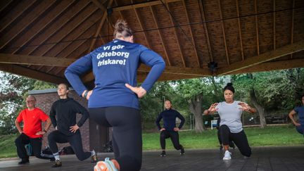 Personer som gör benstyrkeövningar utomhus 