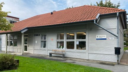 Ljusgrått hus med rött tak och skylt med Öppna förskolan Gårdsten