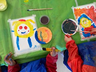 Barn målar av varandra i starka färger.