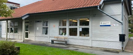 Ett ljusgrått hus med rött tak och skylt Öppna förskolan Gårdsten