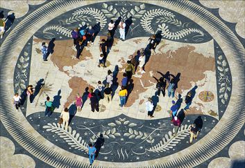 En bild med många människor som syns från ovan, man ser deras skuggor på marken