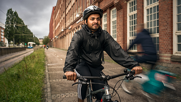Person cyklar på cykelbana, andra cyklister syns i bakgrunden