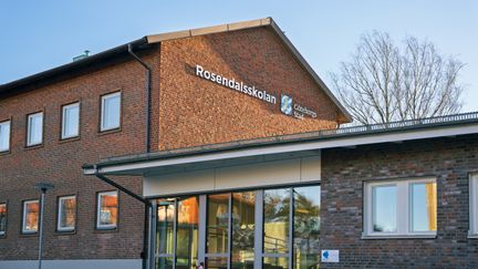 En skolbyggnad i tegel med skylten med Rosendalsskolan på fasaden.