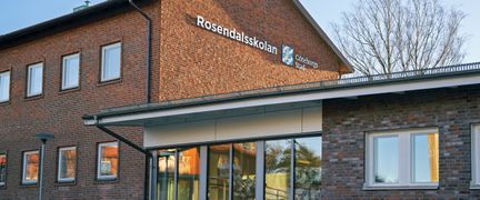 En skolbyggnad i tegel med skylten med Rosendalsskolan på fasaden.