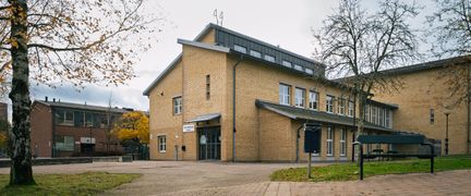 En skolbyggnad i gult tegel med en entré