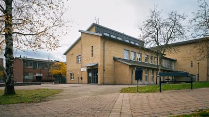 En skolbyggnad i gult tegel med en entré