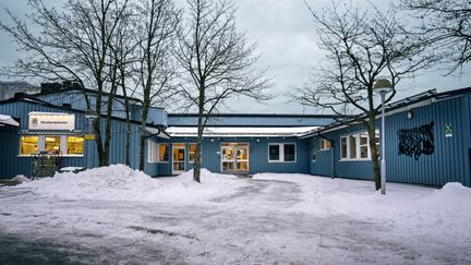 Rävebergsskolans huvudbyggnad med några träd i bakgrunden.