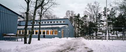 En väg utanför Rävebergsskolan med en skog i bakgrunden.