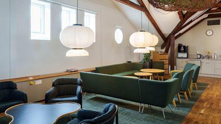 Yta för umgänge med stolar, bord och en stor soffa formad som ett 