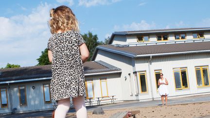 Flicka på gården framför en förskola.