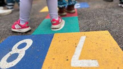 Barnfötter i en färgglad Hoppa hage.