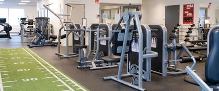 Gymmet i Hammarbadet med träningsmaskiner och en grön matta med vita markeringar.