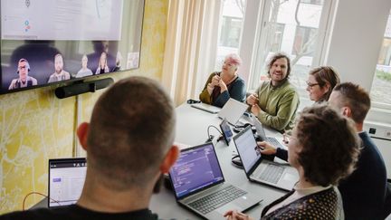 Teamsmöte med fem personer som deltar i mötet fysiskt, och fem andra som deltar digitalt på skärmen. 