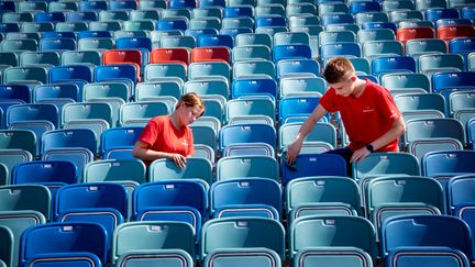 Två ungdomar torkar sittplatser på Ullevi