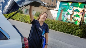 Sjuksköterska stänger bakluckan på sin bil.