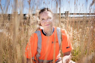 Kvinna i varselkläder i naturmiljö
