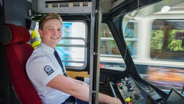 Man klädd i spårvagnsuniform som ler