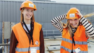 Studenter med bygghjälm och varselvästar