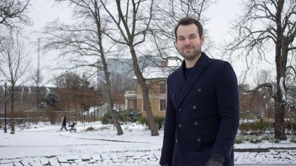 Man i marinblå rock i ett vintrigt Göteborg