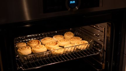 En plåt med kanelbullar i ugnen.