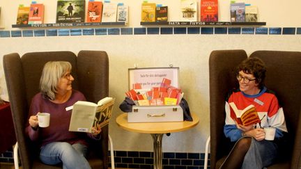 Två kvinnort sitter och läser.