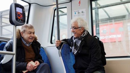 Två äldre män i en spårvagn.