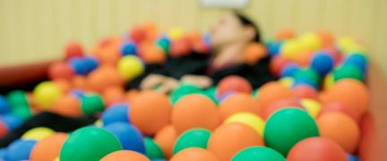 En person ligger i ett bollhav.