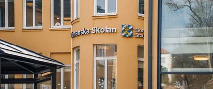 En gul skolbyggnad med texten Ekmanska Skolan på fasaden.