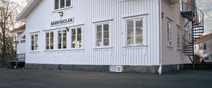 En stor vit skolbyggnad i trä.