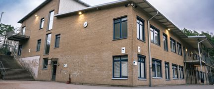 En skolbyggnad i gult tegel med tre våningar