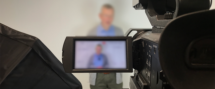 En kamera där man ser en person i sökaren.