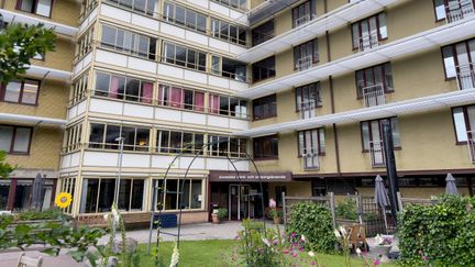 Flervåningshus med gulvit fasad.