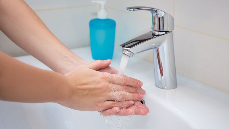 Närbild på en persons händer som tvättas.