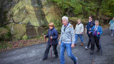 Ett gäng promenerar i naturen, några har stavar andra inte