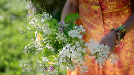 Kvinna håller en bukett med sommarblommor