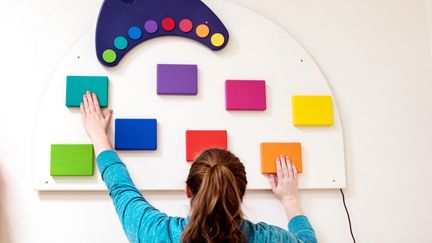 En person trycker på olikfärgade knappar.