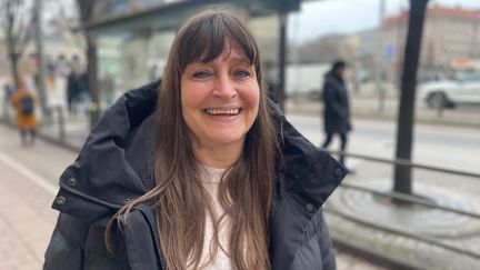 En person står utomhus vid en busshållplats