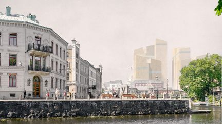 Vallgravens kant i förgrunden brevid en vit byggnad i klassisk stil och centralstationen i bakgrunden.