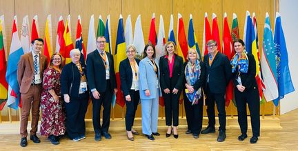 Bild på personer som deltog i WHO:s konferens. Emma Matsson står i mitten iklädd turkosblå kostym. 