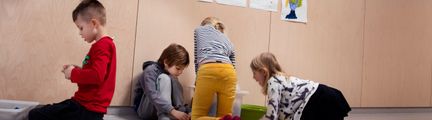Elever leker och bygger på golvet.