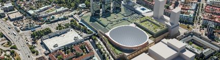 Flygbild över arenakomplex och höghus
