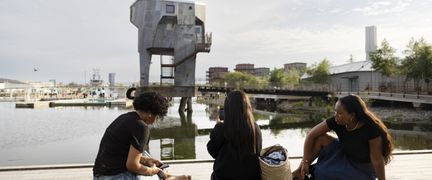 Folk som siter på bryggan och blickar ut över vattnet och bastum