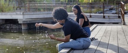 Två personer sitter på bryggan