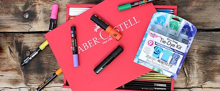 pennor i oilka färger på en röd låda