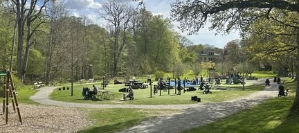 En grönskande park med människor som skymtar
